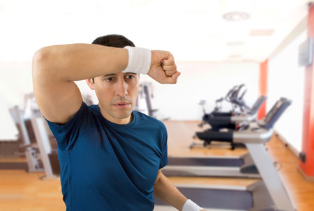 portrait of an athlete standing and wiping sweat after making exercise at the gym