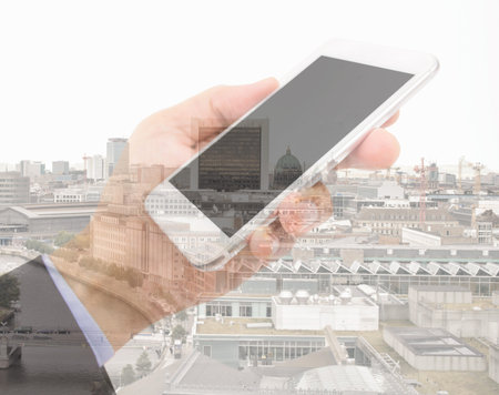 Double exposure image of businessman with smartphone and cityscape in background