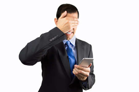 Portrait of an businessman covering his eyes because he not want to look the phone caller isolated on white backgroundの写真素材
