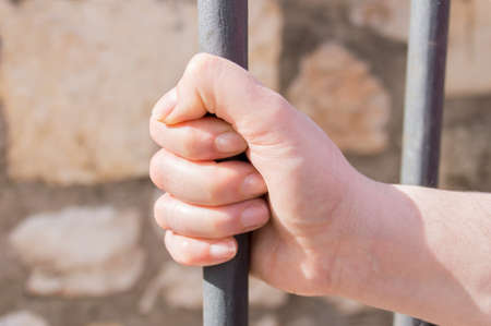 hand of woman holding the iron bar at the prisonの写真素材