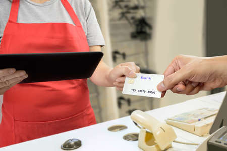 man handing over her credit card to a salesperson.All screen content is designed by us and not copyrighted by others and created with digitizing tablet and image editorの写真素材