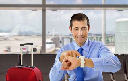 businessman looking his wrist watch at the lobby of airportの写真素材