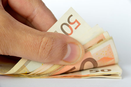 close up of hand a successful businessman counting his profits with money
