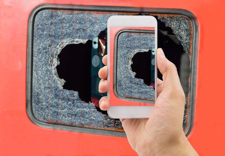 Man photographing the broken glass of your industrial van