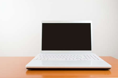 Modern laptop isolated on white with wood table and copyspaceの写真素材