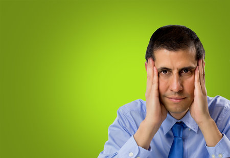 businessman thinking and focused with hands on face and green background