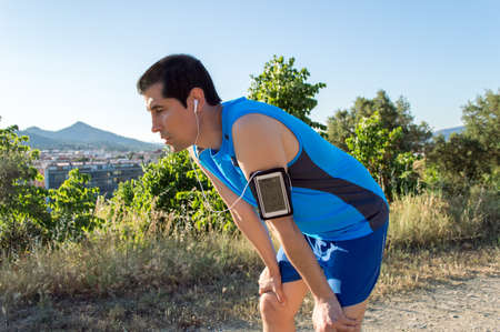 Runner resting after running taking a break during training outdoors at the mountain trailの写真素材