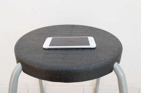 Forgotten smartphone on a chair of a waiting roomの写真素材