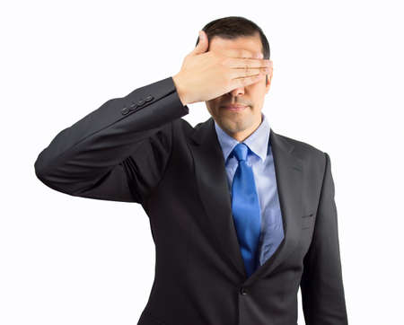 Portrait of an businessman covering his eyes isolated on white backgroundの写真素材