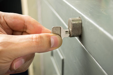 closeup of hand man is opening the cabinet with the key