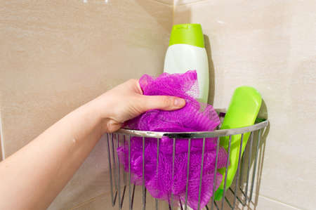 hand of one young woman catch her sponge in the showerの写真素材