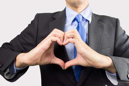 business man making the heart shape with his hands as concept of he loves his businessの写真素材