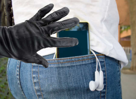 close up of a the hand of a thief stealing the phone to a womanの写真素材