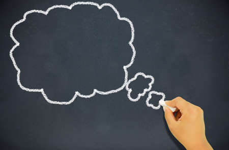 Thought bubble blackboard / chalkboard. Thought bubble drawing with chalk on black chalkboard. Copy space for text. Nice background texture.の写真素材