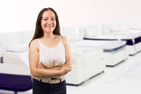 saleswoman of mattresses  with arms crossed and smiling at a home and decoration storeの写真素材