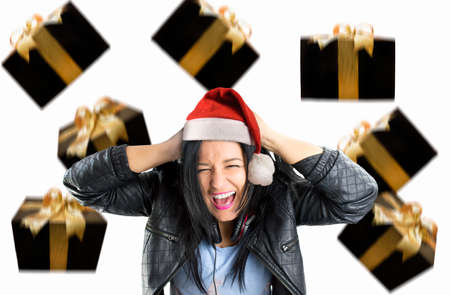 young woman screaming with rain  gifts at christmas with santa hatの写真素材