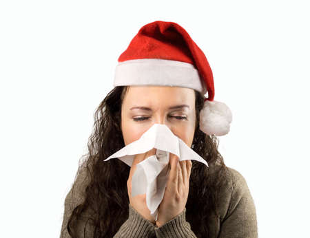 sneezing woman sick blowing nose with santa hat and white backgroundの写真素材