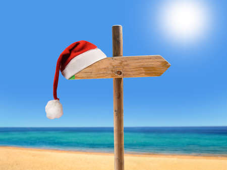 one wooden signpost in the beach with copyspace at Christmas with santa hatの写真素材