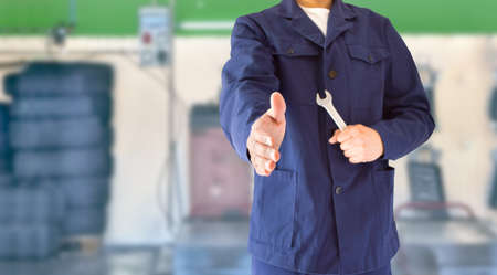 worker mechanic welcoming the repairing car workshopの写真素材