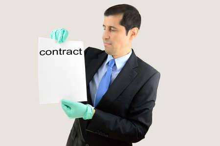 Angry businessman taking a document with gloves and expression in face of rejection and revulsion over white backgroundの写真素材