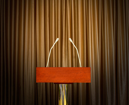 empty podium with microphones over curtains in background