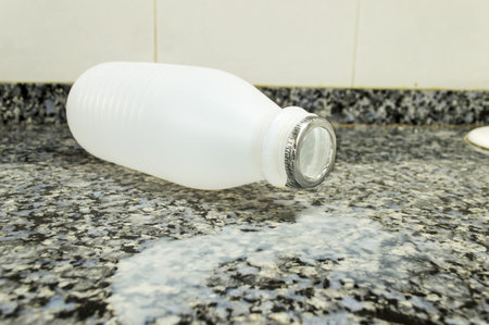 empty plastic bottle fall on the counter kitchen with milk over the surface
