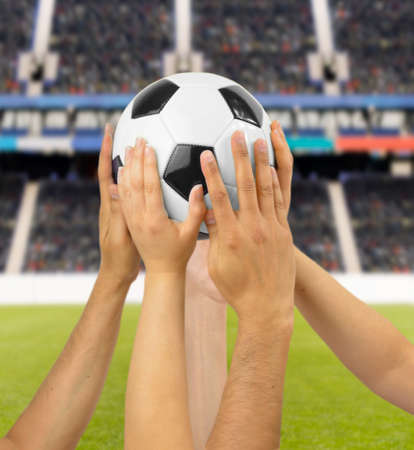 Group of football players holding a soccer ball at football stadiumの写真素材