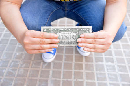 lucky young people finding a dollar bill on the streetの写真素材