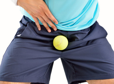 man playing tennis being hit by a tennis ball with force in the crotch when he misses a catch or as...