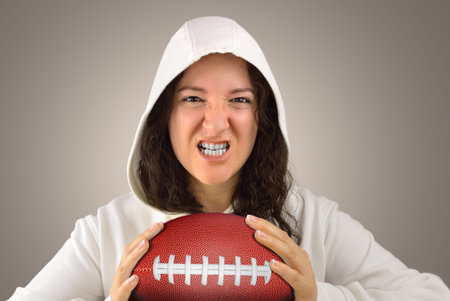 Cropped portrait of a young american football player shouting passionately while holding the match...