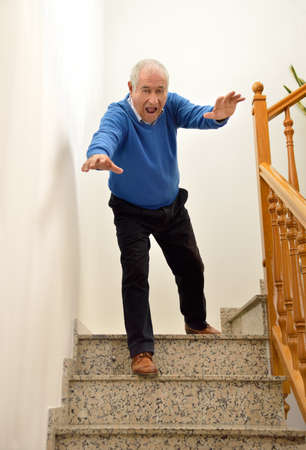 senior man falling down on the stairsの写真素材