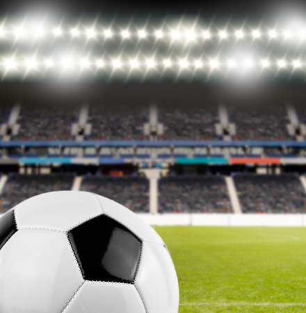 cropped shot of soccer ball at the football stadium with the spotlights illuminating the field with copyspace