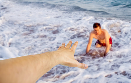 Cropped shot of men helping each other at beach