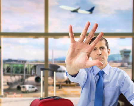 Businessman hand showing stop hand at airport departure loungeの写真素材