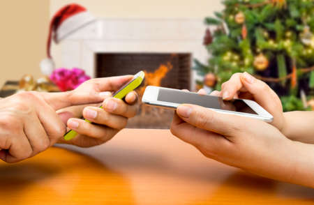 Two people with smart phones connecting with wifi at liveroom in Christmasの写真素材