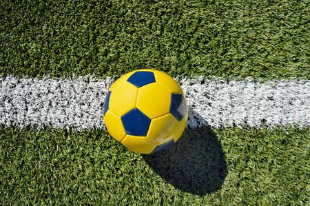 shot of a traditional soccer ball soccer on soccer field with yellow and blue colorsの写真素材