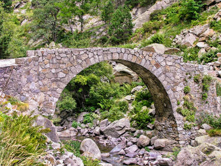 A narrow stone bridge in mountain area in the northern part of Spain, Pyrenees Cataloniaの写真素材