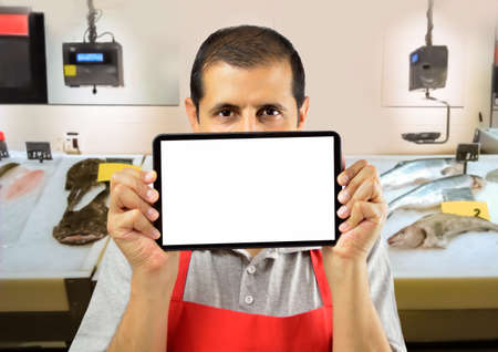 fishnet holding tablet over his mouth with copyspace in blank at the fishmongerの写真素材