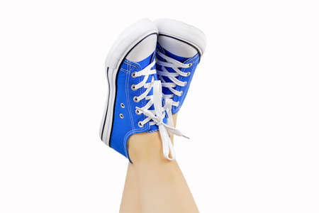Studio shot of a woman's legs with sneakers isolated on white の写真素材