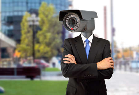 management surveillance at the office with a man wearing a surveillance camera as headの写真素材