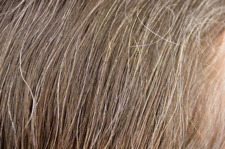 Close-up of woman whit gray hair roots
