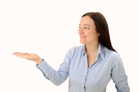 Lovely brunette smiles and gestures towards the copyspace next to herの写真素材