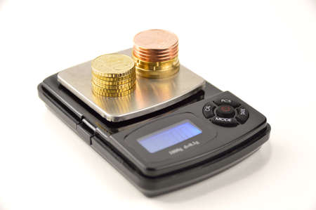 coins on a scale in concept as the money price isolated on whiteの写真素材
