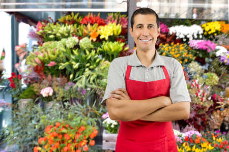 Shot of a shop man with crossed arms in a garden shop with plants and flowersの写真素材