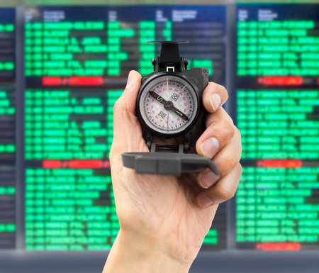 close-up of a hand with a compass at international airport.Concept of destination decision