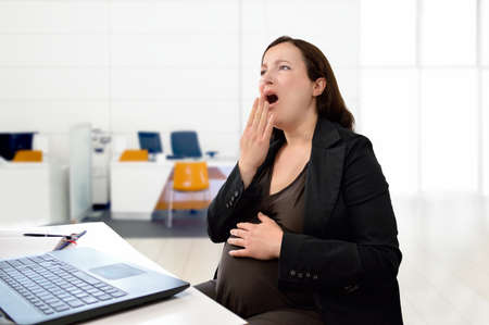 pregnant woman sleeping in her officeの写真素材