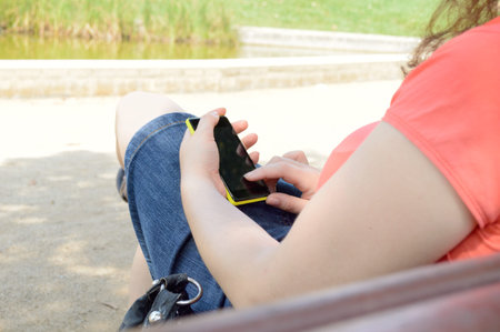 Shot of a young woman using her cellphone at park