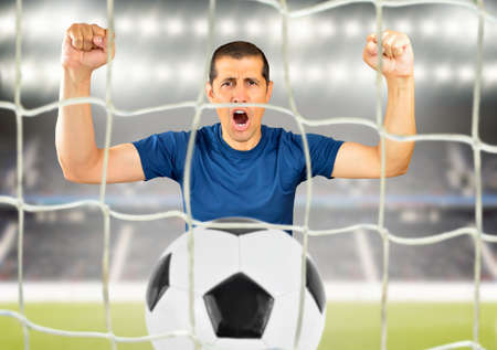 Cropped shot of a young soccer player celebrating his victory at stadiumの写真素材