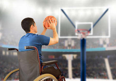 rear view of a basketball player in free throw pose in wheelchair at stadiumの写真素材