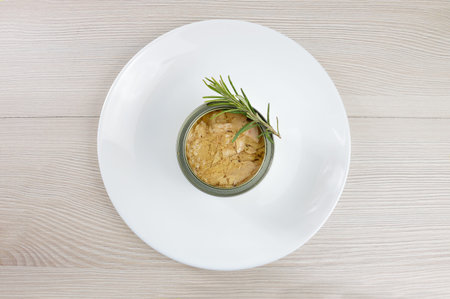 High angle shot of delicious can of tuna on a plate on rustic wooden table